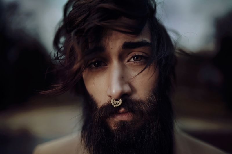 Zarastený a fúzatý muž v s piercingom v nose septum