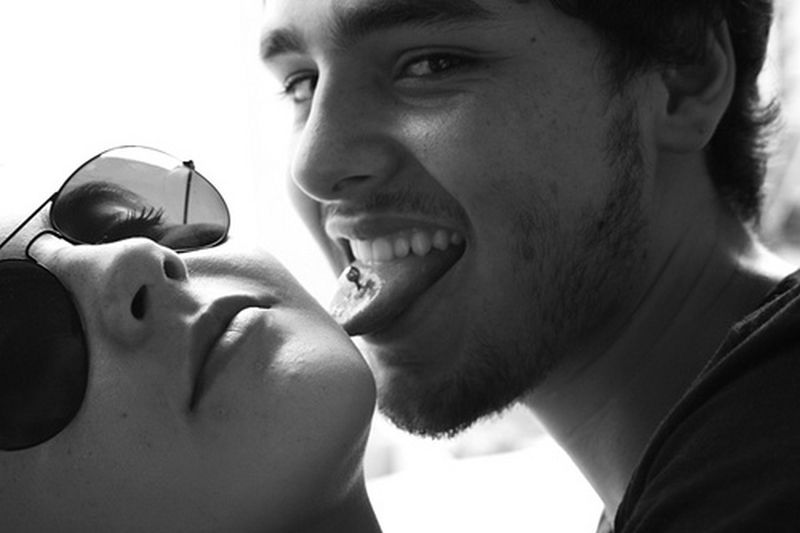 Mladý pár, chlapec s piercingom v jazyku