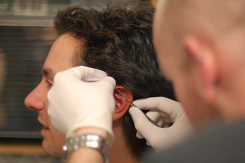 Muž si necháva urobiť piercing ucha v štúdiu